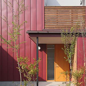 赤いガルバリウム鋼板と木板張りのナチュラルモダンな住宅の外観,玄関ポーチ