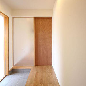 シンプルなナチュラル和モダン住宅の玄関,木製の引戸が印象的