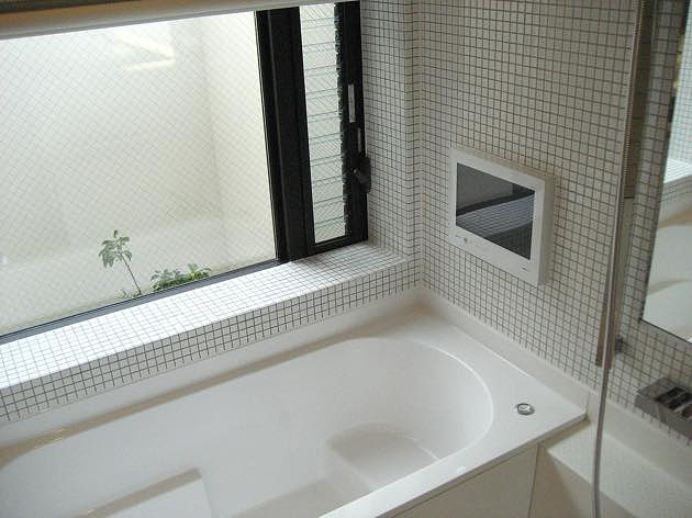 モダンデザインの住宅,中庭ライトコートに面したタイル貼りの浴室,テレビ付き浴室,中庭の緑の見える浴室